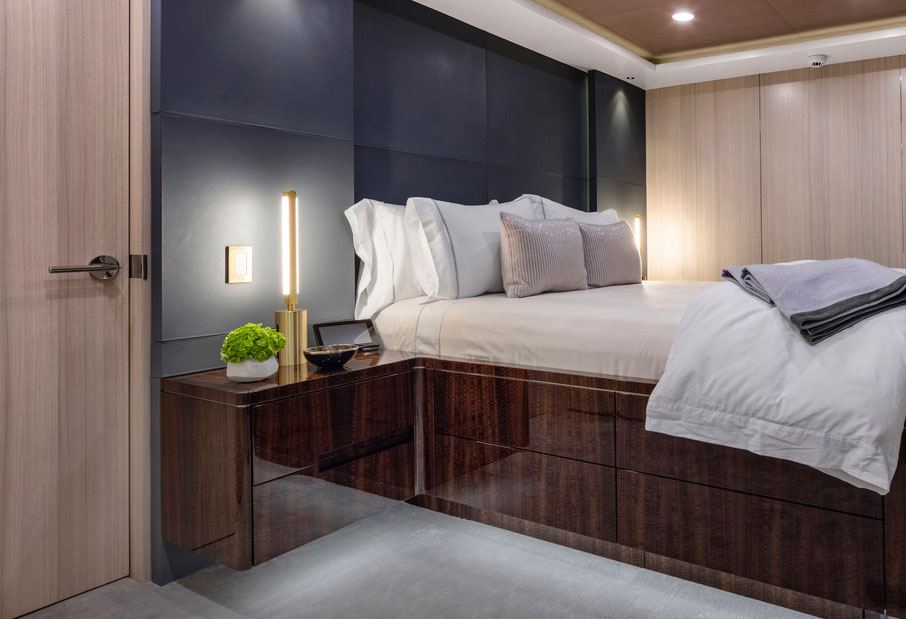 A pair of Pris table lamps with satin brass metal components flank a built in platform bed.