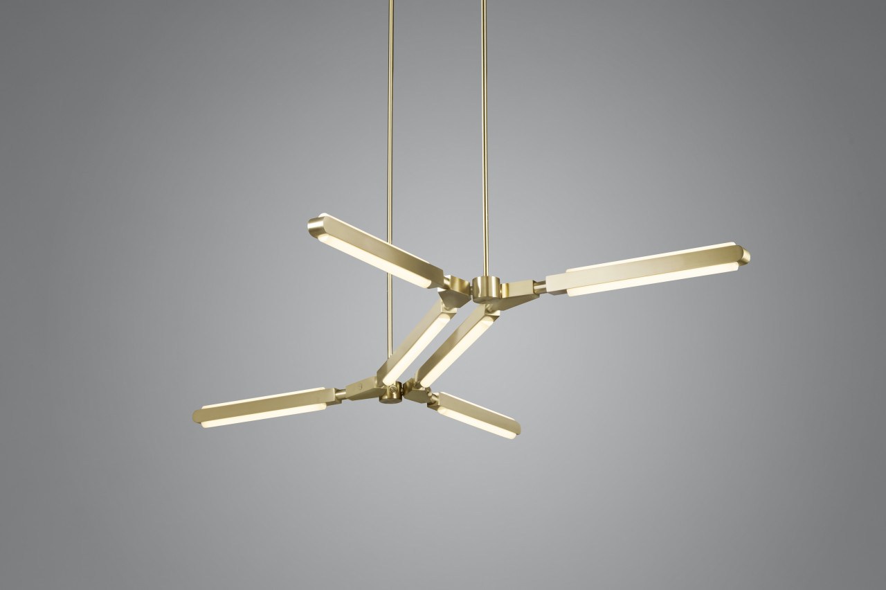 View up at an illuminated Pris Minor chandelier with satin brass metal components .