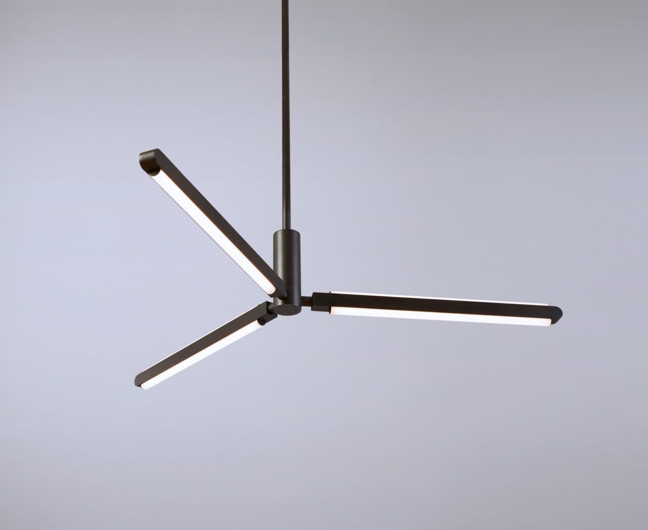 View up at an illuminated Pris Y chandelier with black brass metal components.