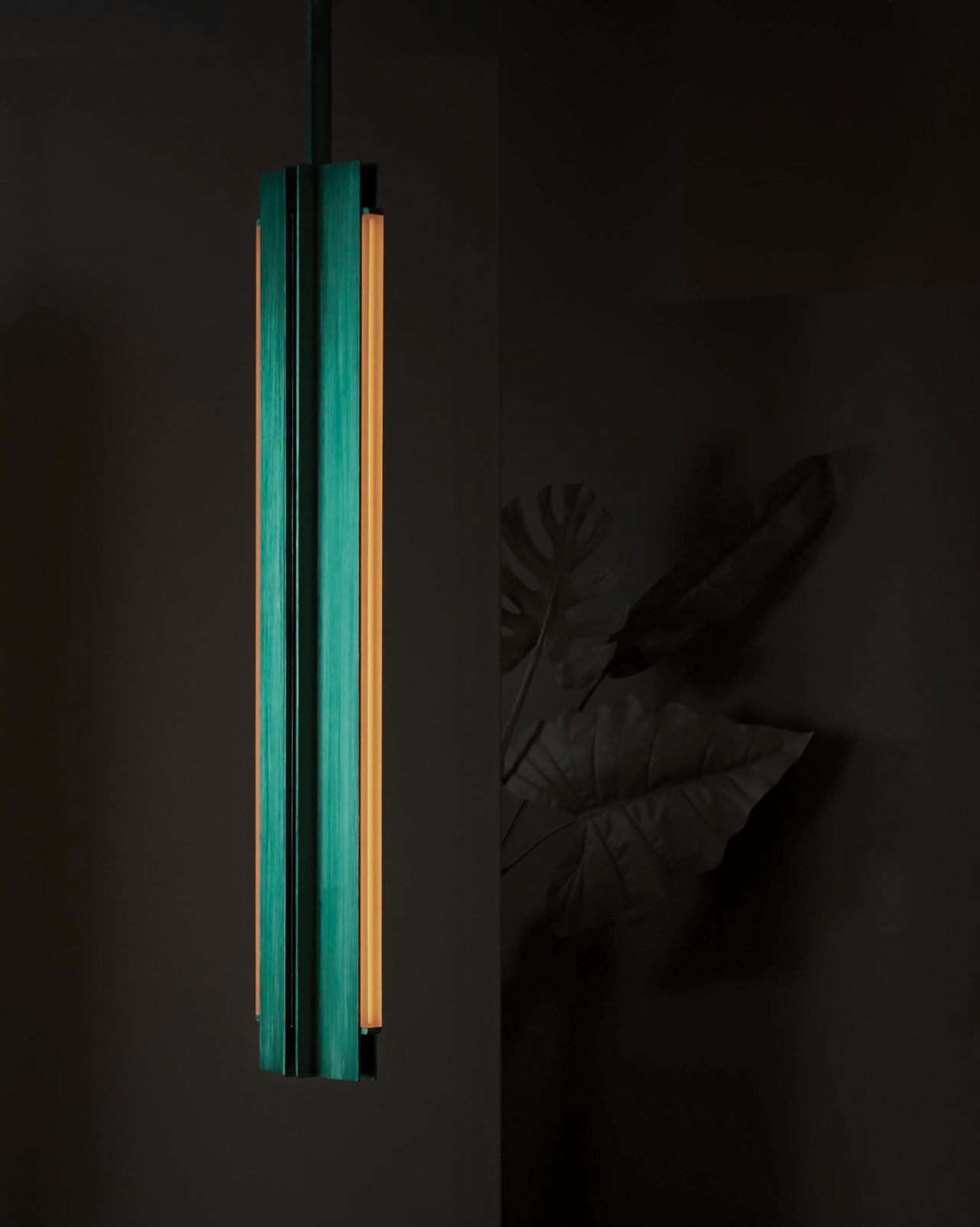 Three quarter view of Pelle’s Beam 04 Pendant in hand-stained green with amber lens.