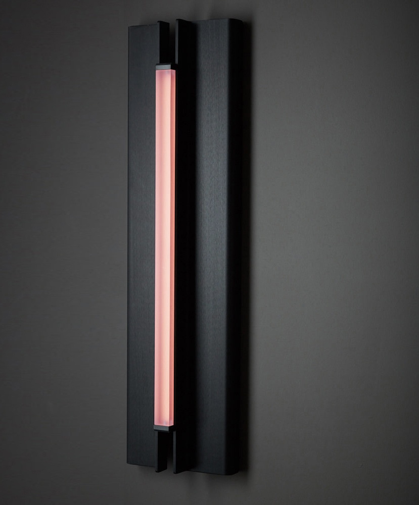 Three quarter view of Pelle’s Glow 02 Sconce in anodized black with rose lens.