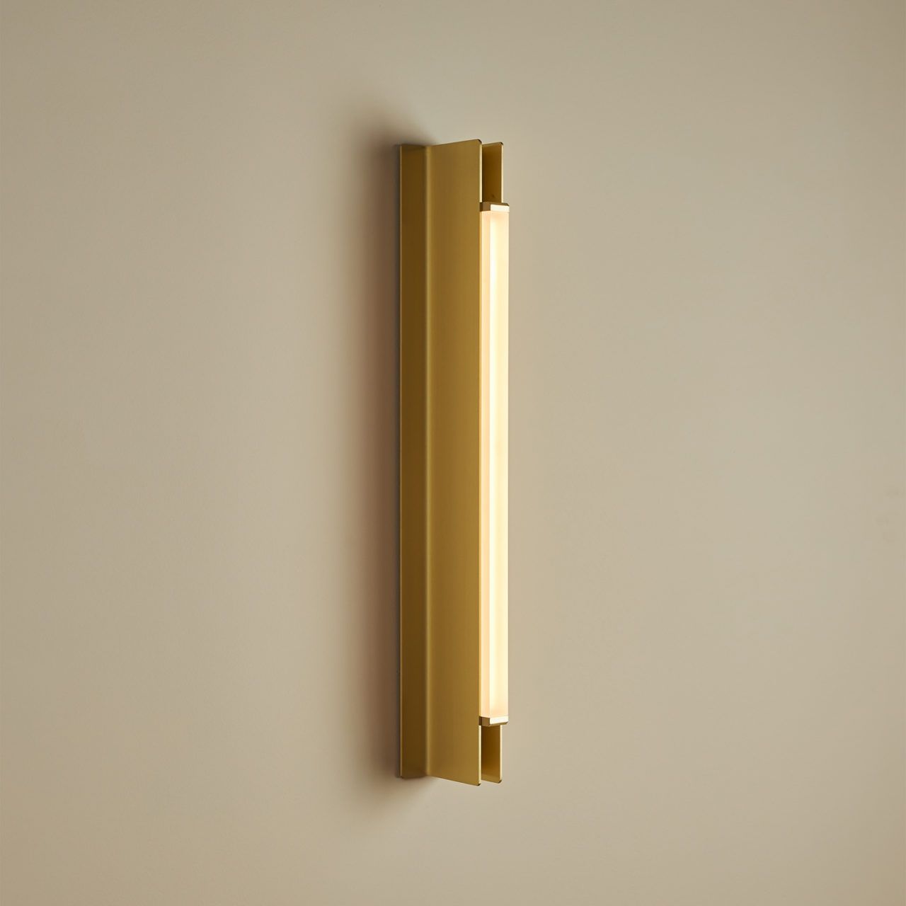 Three quarter view of Pelle’s Beam 02 Sconce in anodized gold with frosted lens.