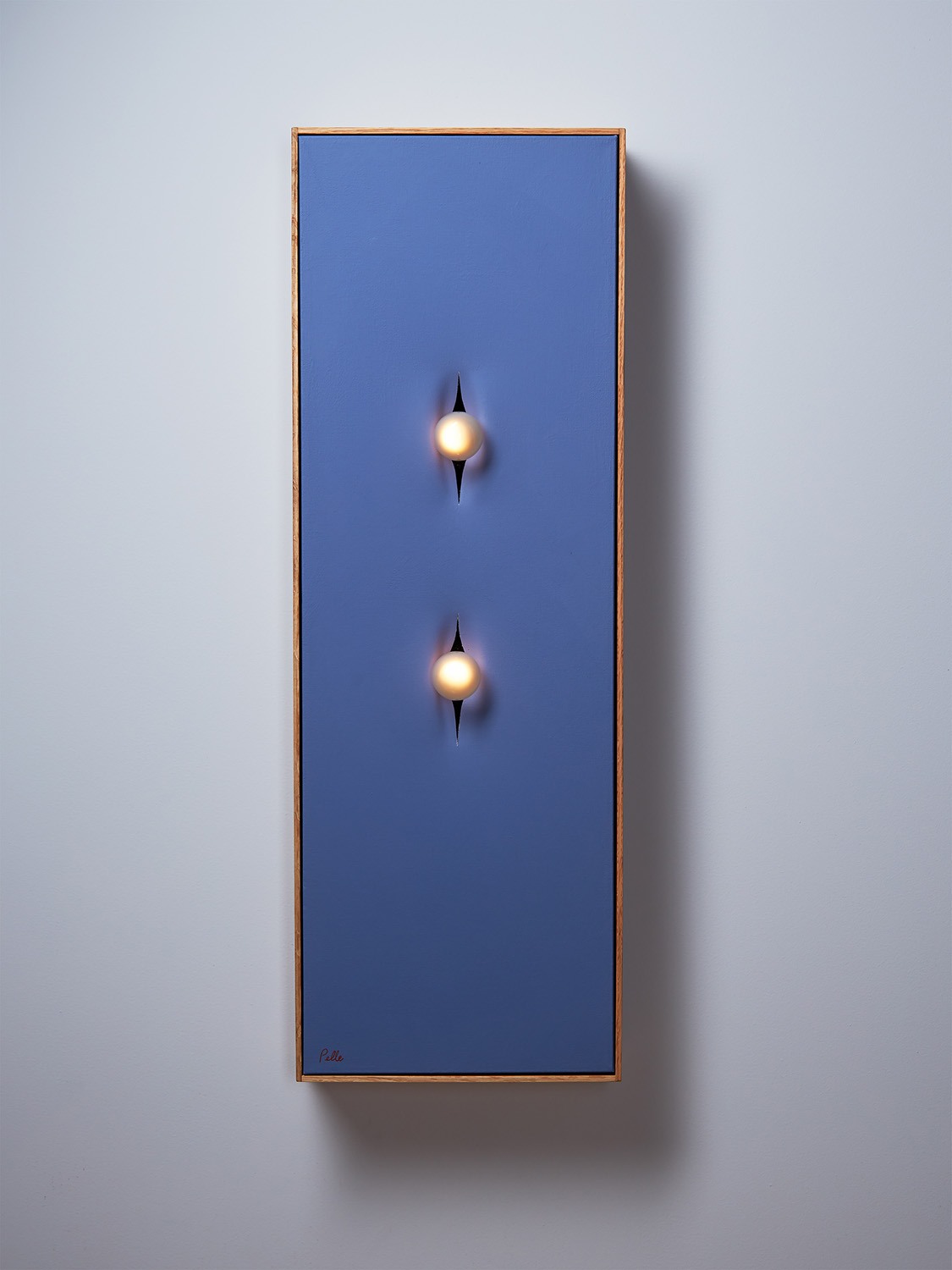 Pelle’s Incise 12x36 wall light, with two bulbs set in blue violet canvas.