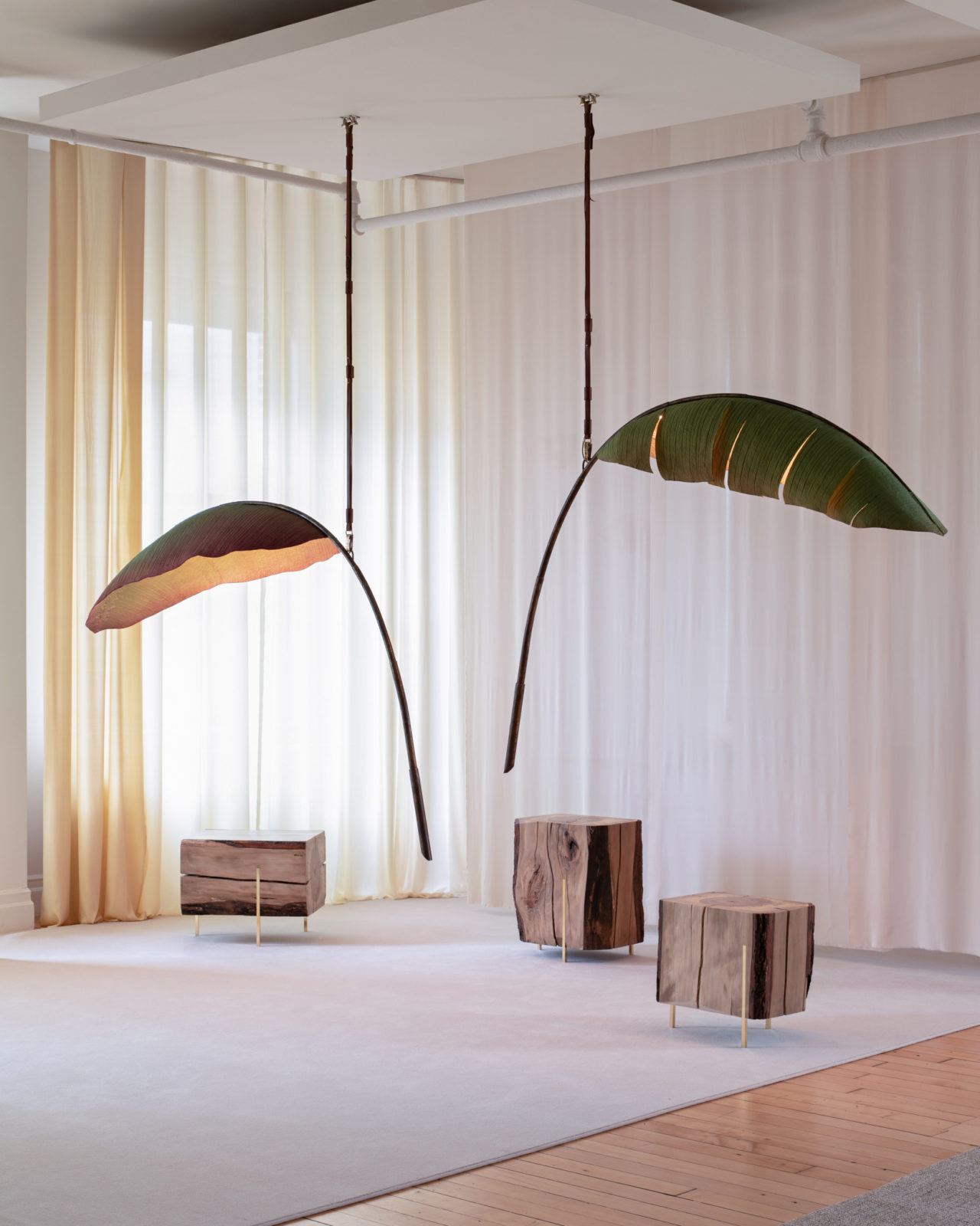 Two of Pelle's Nana Lure lamps suspended above three Stiletto Stools