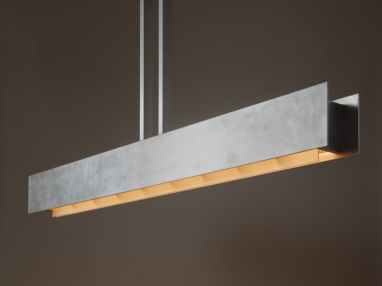 Three quarter view of Pelle’s illuminated Be Patient fixture, made of hand-finished aluminum panels.