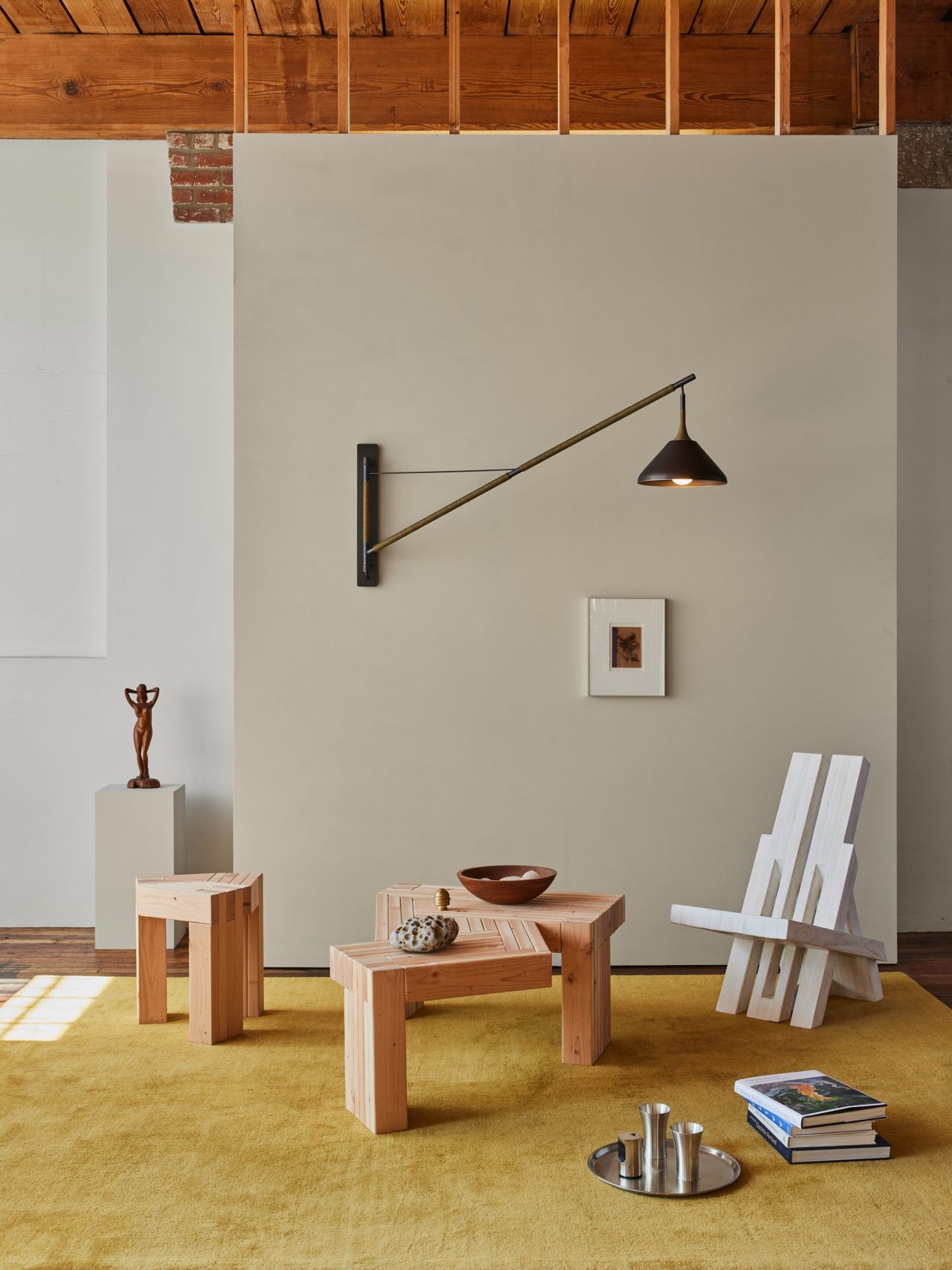 Pelle’s Stem Shade Rig Wall Lamp in a styled vignette with mustard rug, 2x4 furniture and unique accessories.